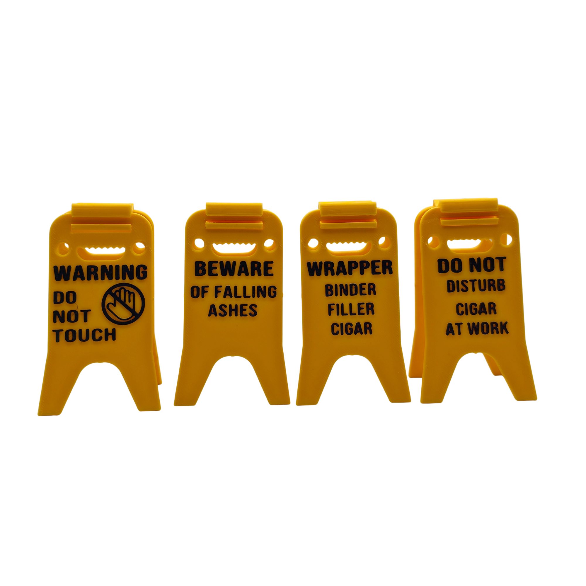 Bright yellow 3D printed cigar holder styled like a classic wet floor caution sign, printed with humorous cigar-related phrases in black text. The foldable design allows the sign to stand upright and serve as a portable cigar rest that keeps cigars elevated and off tables.