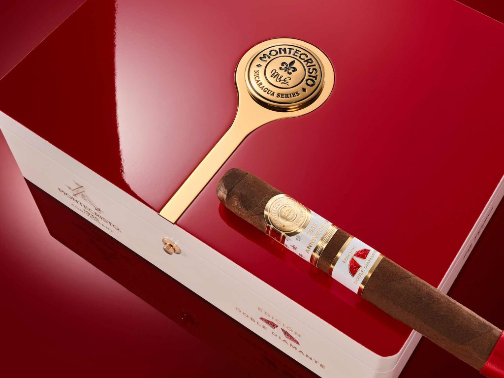 cigar box with red lid. on top of the box is a cigar